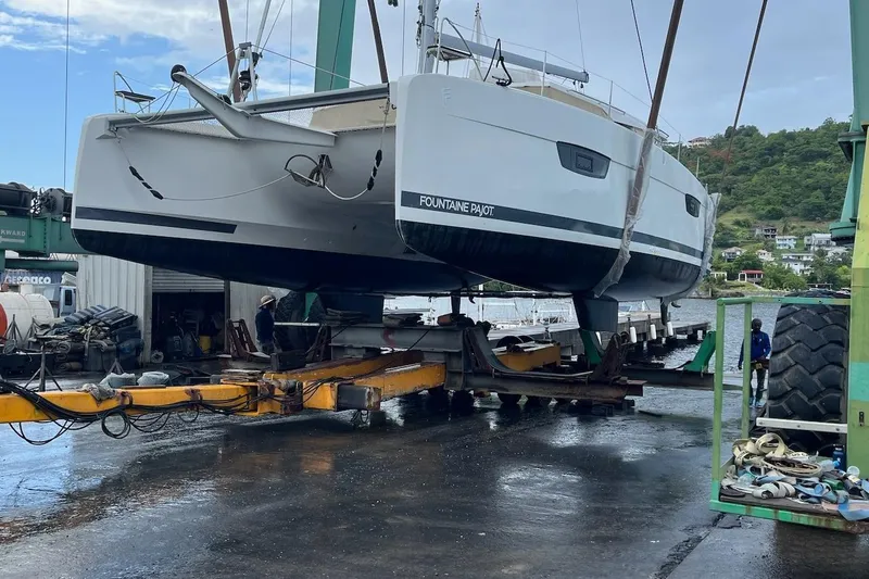 Honu Kai Yacht Photos Pics 2023 Fountaine Pajot Catamaran Astrea 42 being lifted at a marina.