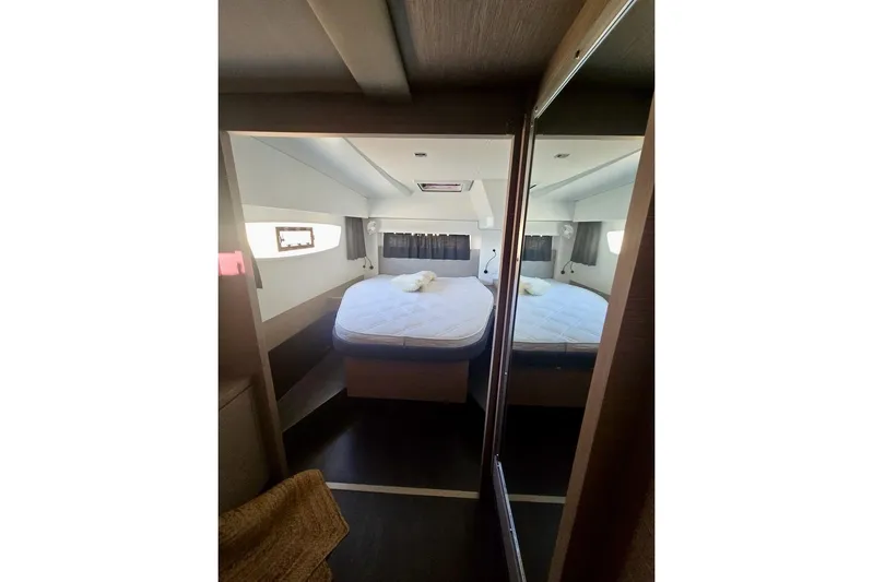 Honu Kai Yacht Photos Pics 2023 Fountaine Pajot Catamaran Astrea 42 cabin interior with bed and window view.