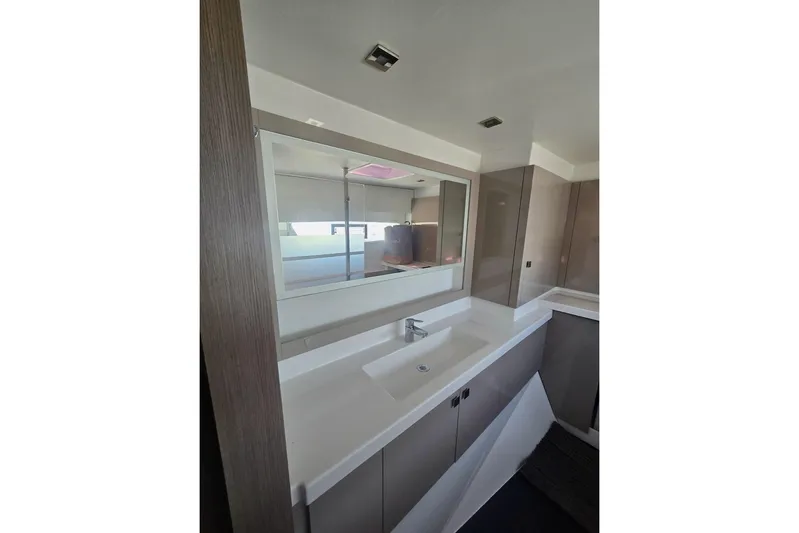 Honu Kai Yacht Photos Pics Modern bathroom interior of 2023 Fountaine Pajot Catamaran Astrea 42, featuring sleek design.