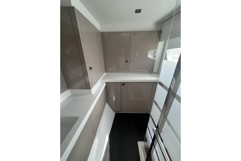 Honu Kai Yacht Photos Pics Modern kitchen interior of 2023 Fountaine Pajot Catamaran Astrea 42, featuring sleek cabinetry.