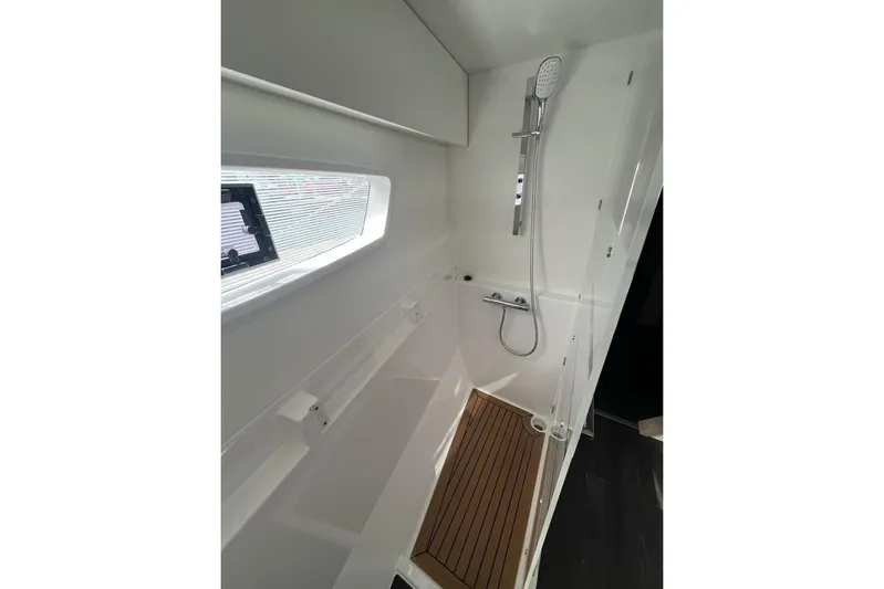 Honu Kai Yacht Photos Pics Modern shower area in 2023 Fountaine Pajot Catamaran Astrea 42 with sleek design and wooden flooring.