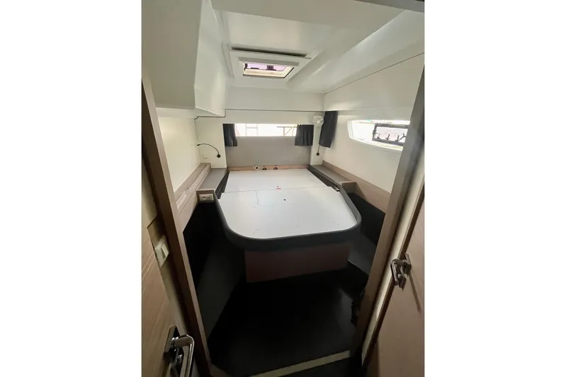 Honu Kai Yacht Photos Pics Interior cabin of 2023 Fountaine Pajot Catamaran Astrea 42, featuring a spacious bed and windows.