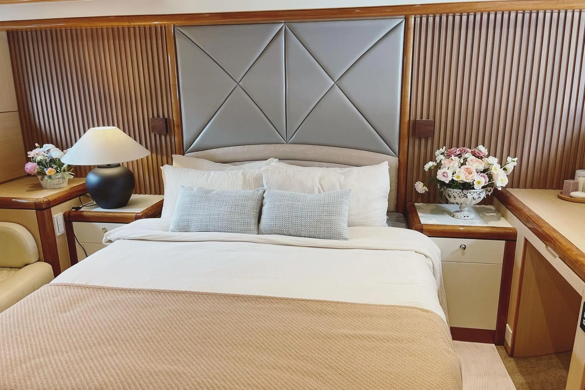 Luxurious bedroom interior on a 2007 Ruby 55 yacht, featuring elegant decor and floral arrangements.