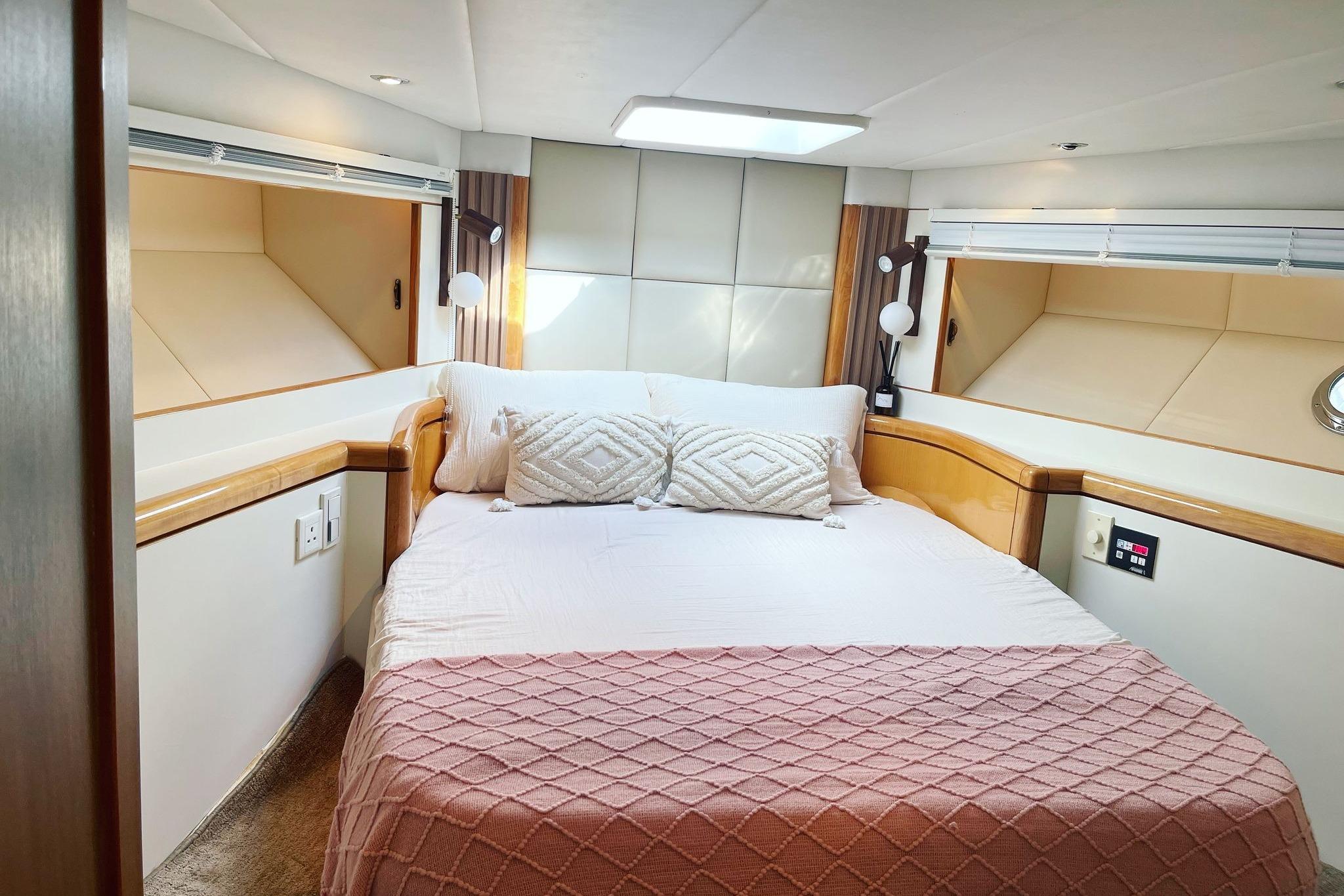 Luxurious bedroom interior in a 2007 Ruby 55 yacht, featuring elegant bedding and modern lighting.
