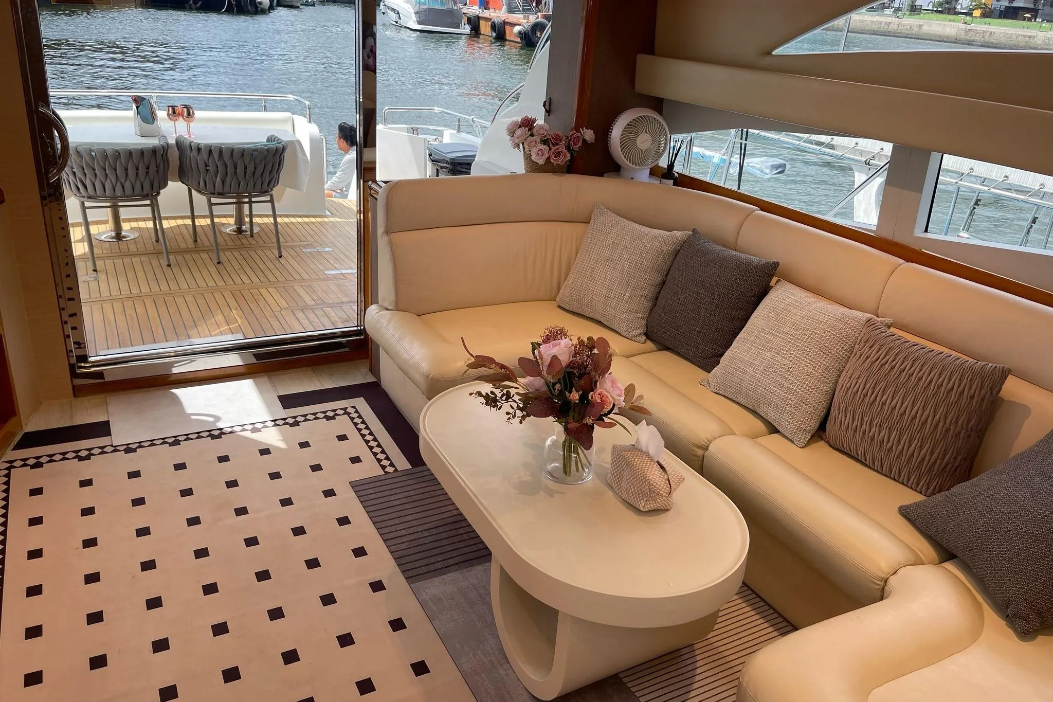 Luxurious Ruby 55 yacht interior with elegant seating, floral centerpiece, and waterfront view, 2007 model.