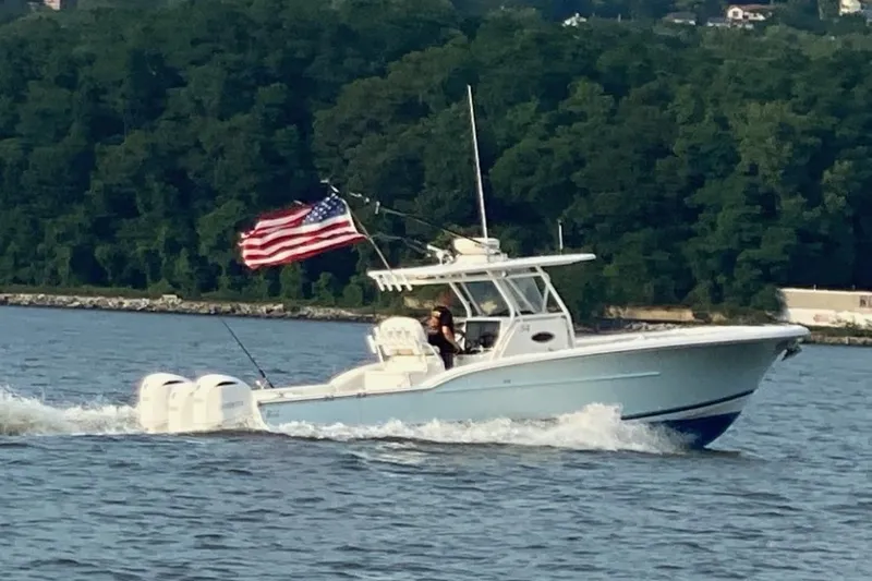  Yacht Photos Pics 2017 Buddy Davis 34 Center Console boat cruising with American flag on water.