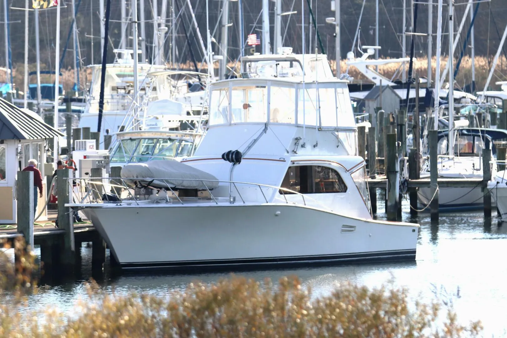1985 Post 43 Sport Fisherman yacht docked in a marina, surrounded by other boats.