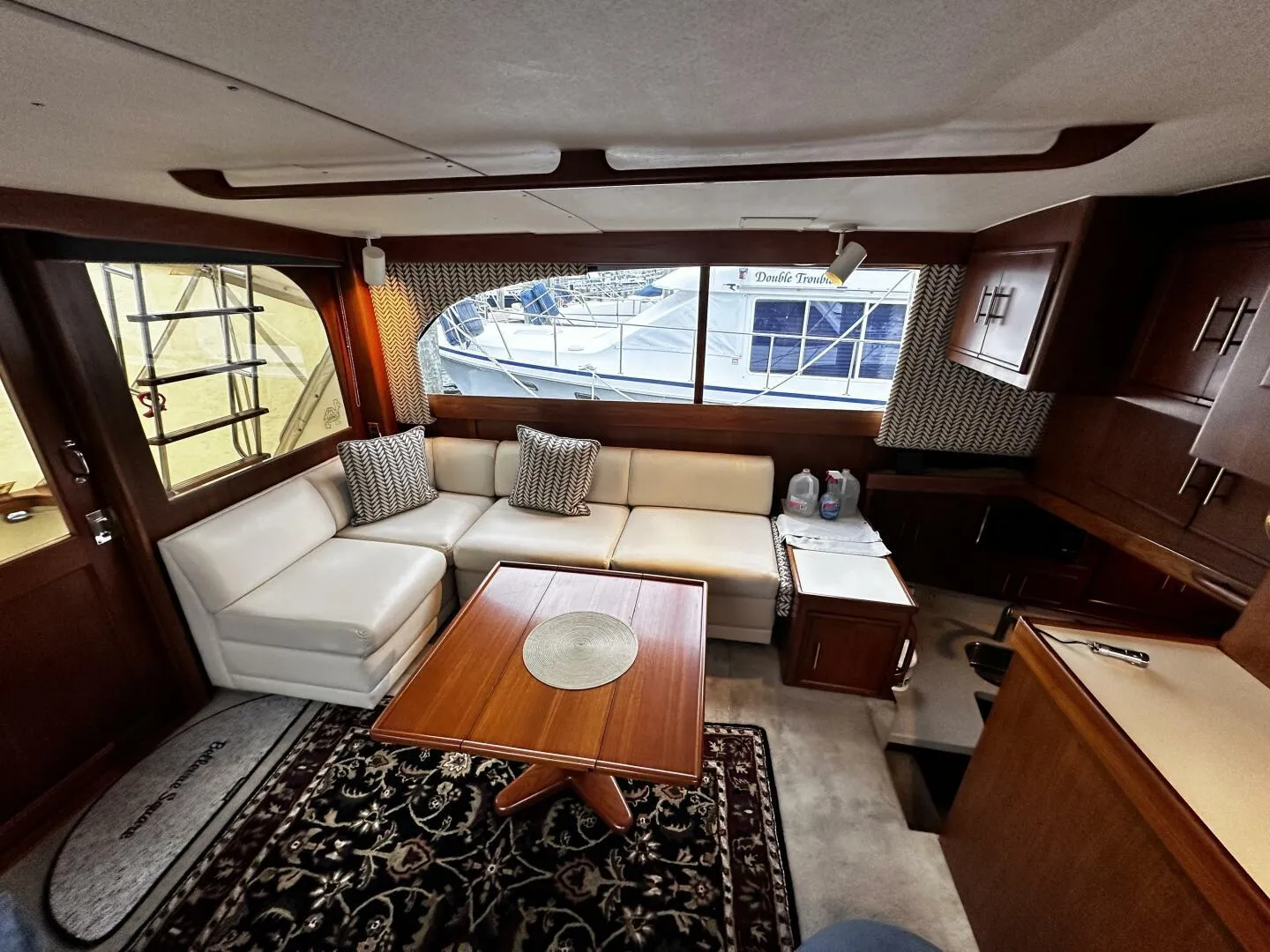 Interior of 1985 Post 43 Sport Fisherman yacht with white seating and wooden accents.