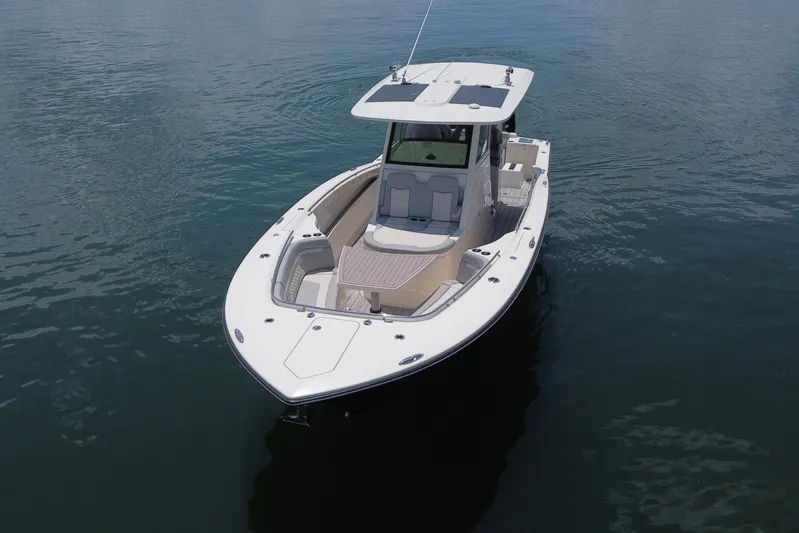  Yacht Photos Pics 2021 Scout 330 LXF boat on calm water, showcasing sleek design and spacious deck.