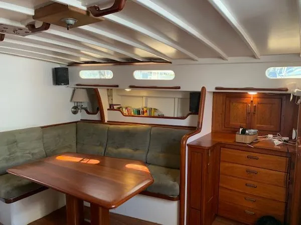  Yacht Photos Pics Cozy 1988 Ocean Custom boat interior with wooden table, cushioned seating, and built-in storage.
