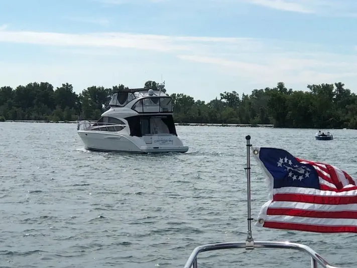 Continuous Wave Yacht Photos Pics 2007 Meridian 391 yacht cruising on a lake with American flag in foreground.