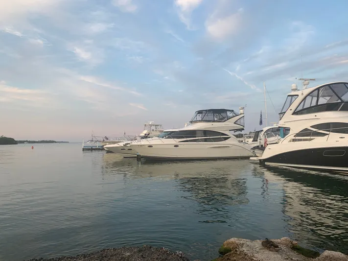 Continuous Wave Yacht Photos Pics Luxury yachts, including a 2007 Meridian 391, docked at a serene marina under a cloudy sky.