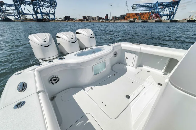 36 Offshore Yacht Photos Pics 2025 Yellowfin 36 Offshore boat with triple engines, docked near industrial port cranes.