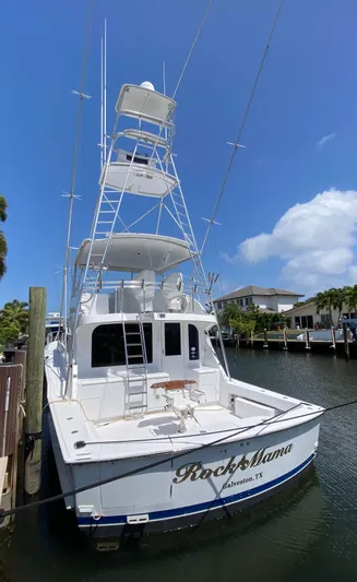 Rock Mama Yacht Photos Pics 2001 Hatteras 55 Convertible yacht docked in a marina under a clear blue sky.