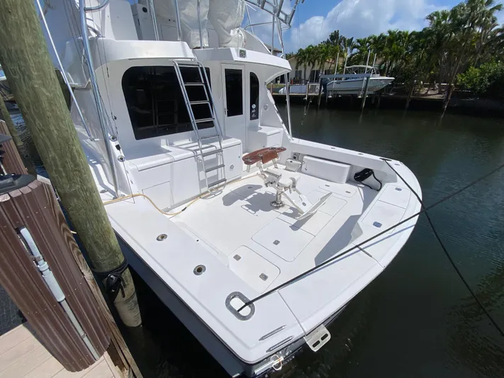 Rock Mama Yacht Photos Pics 2001 Hatteras 55 Convertible yacht docked, featuring spacious deck and fishing chair.