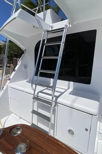 Rock Mama Yacht Photos Pics 2001 Hatteras 55 Convertible yacht with ladder and sleek white exterior.