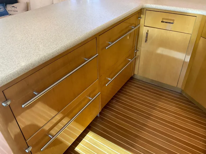 Rock Mama Yacht Photos Pics Modern kitchen cabinetry on a 2001 Hatteras 55 Convertible yacht, featuring sleek wooden drawers.
