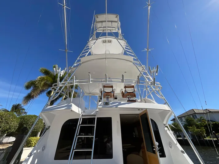 Rock Mama Yacht Photos Pics 2001 Hatteras 55 Convertible yacht with tower, docked under clear blue sky.