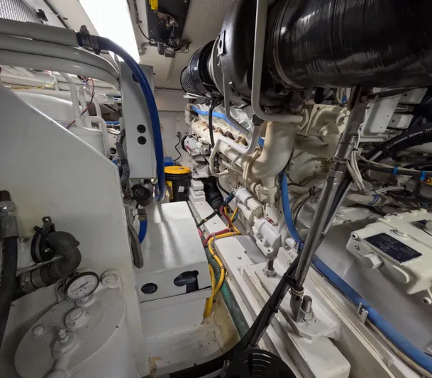 Rock Mama Yacht Photos Pics Engine room of 2001 Hatteras 55 Convertible yacht, showcasing mechanical components and piping.