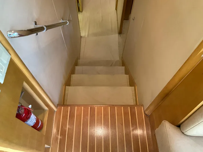 Rock Mama Yacht Photos Pics Staircase inside 2001 Hatteras 55 Convertible yacht with wooden steps and handrail.