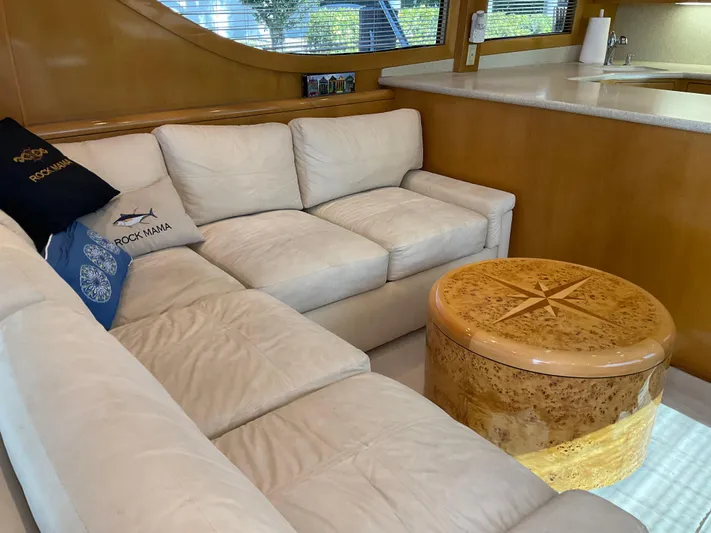 Rock Mama Yacht Photos Pics Luxurious interior of 2001 Hatteras 55 Convertible yacht with white sofa and wooden table.