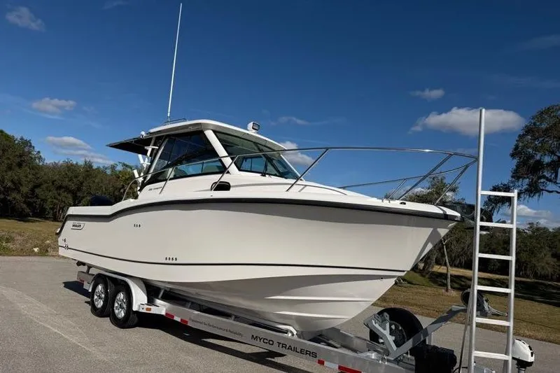  Yacht Photos Pics 2017 Boston Whaler 285 Conquest boat on trailer under clear blue sky.