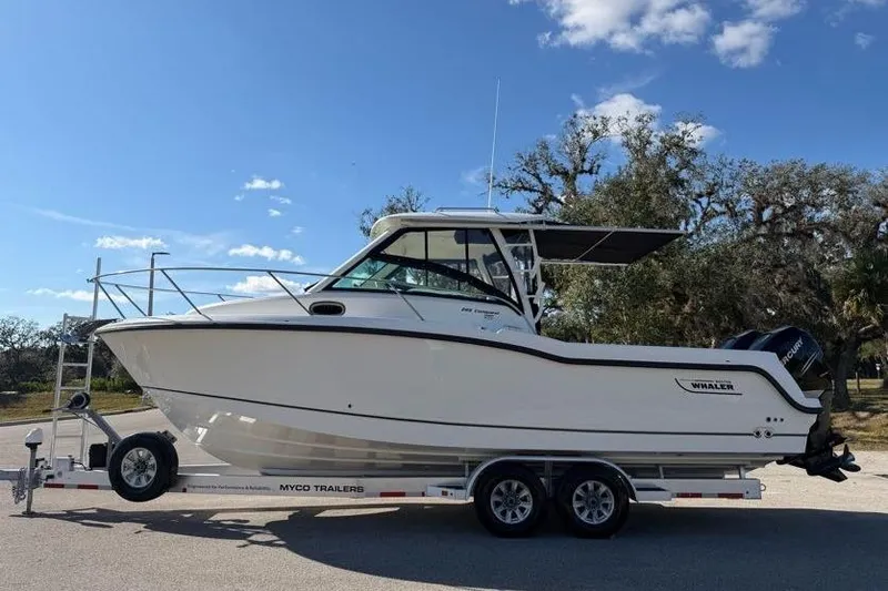  Yacht Photos Pics 2017 Boston Whaler 285 Conquest boat on trailer under clear sky.