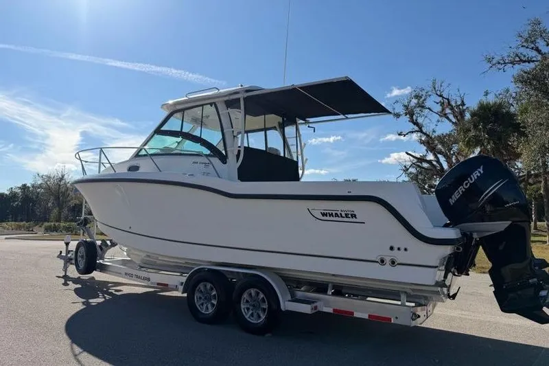  Yacht Photos Pics 2017 Boston Whaler 285 Conquest boat on trailer, parked outdoors under clear sky.