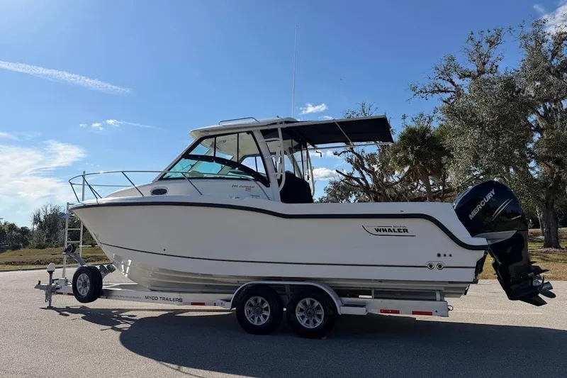  Yacht Photos Pics 2017 Boston Whaler 285 Conquest boat on trailer under clear blue sky.