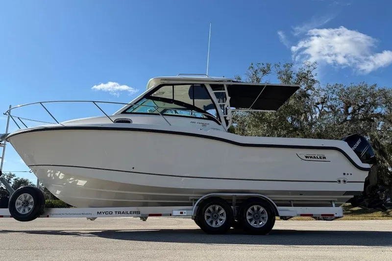 Yacht Photos Pics 2017 Boston Whaler 285 Conquest boat on trailer under clear blue sky.