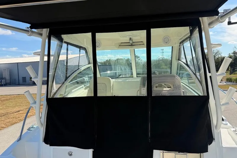  Yacht Photos Pics 2017 Boston Whaler 285 Conquest boat with black canvas enclosure, docked outdoors.