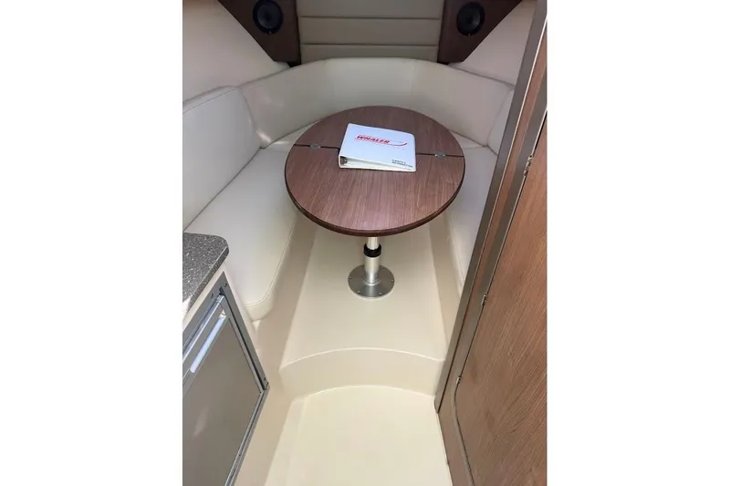  Yacht Photos Pics 2017 Boston Whaler 285 Conquest cabin interior with table and seating area.