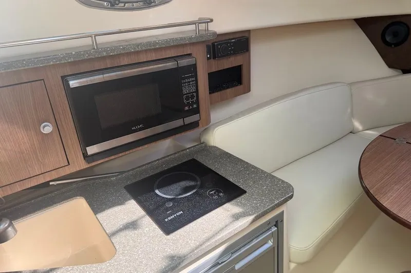  Yacht Photos Pics Interior of 2017 Boston Whaler 285 Conquest with kitchenette and seating area.