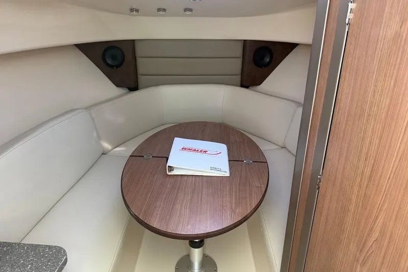  Yacht Photos Pics Interior of 2017 Boston Whaler 285 Conquest with cozy seating and wooden table.