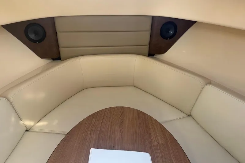  Yacht Photos Pics 2017 Boston Whaler 285 Conquest cabin interior with beige seating and wood table.