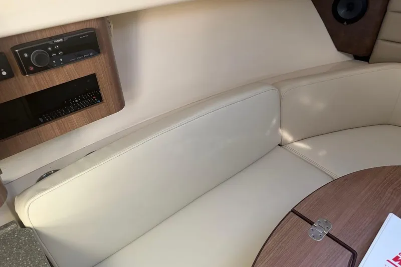  Yacht Photos Pics Interior of 2017 Boston Whaler 285 Conquest with beige seating and wooden table.