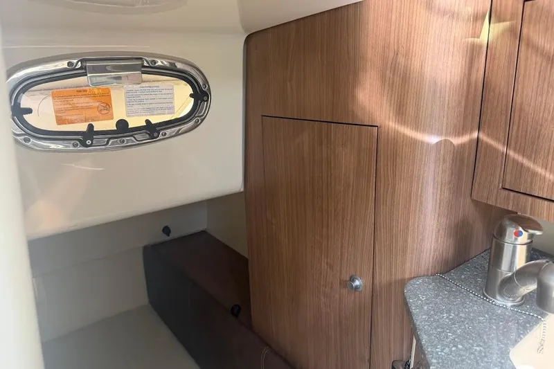  Yacht Photos Pics 2017 Boston Whaler 285 Conquest cabin interior with wood paneling and porthole window.
