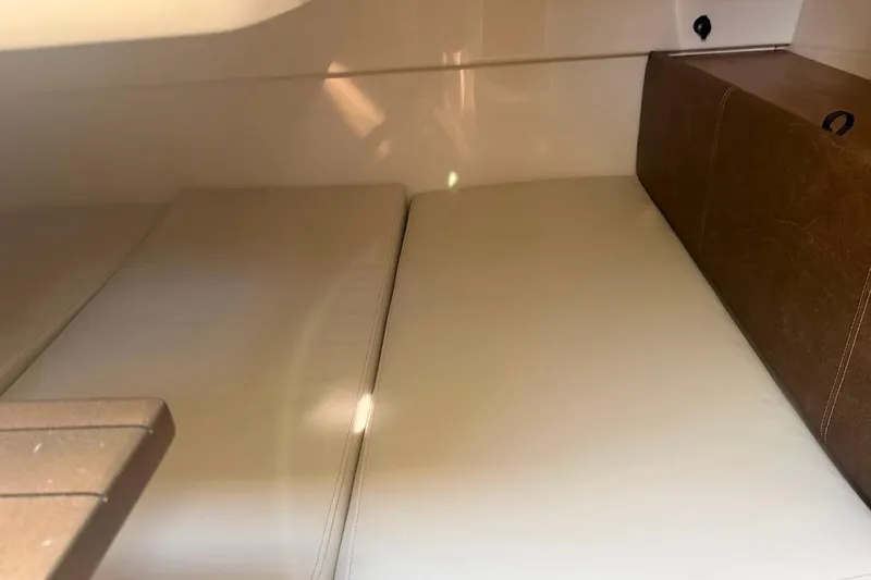  Yacht Photos Pics 2017 Boston Whaler 285 Conquest cabin interior with beige cushions and brown accents.