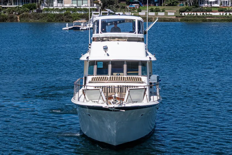 Maverick Yacht Photos Pics 1979 Hatteras 58 Motor Yacht cruising on a serene blue lake.