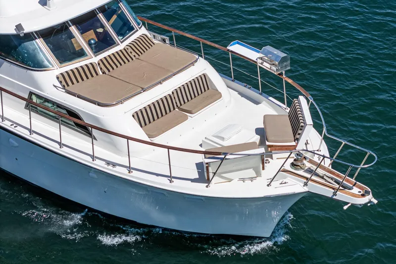 Maverick Yacht Photos Pics 1979 Hatteras 58 Motor Yacht cruising on blue water, featuring spacious deck seating.