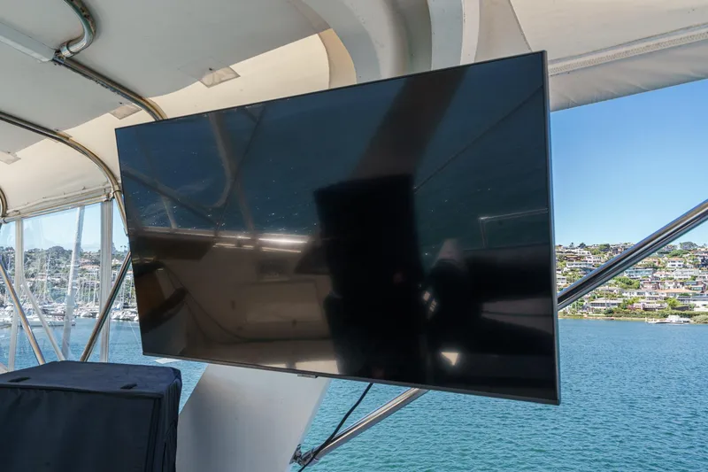 Maverick Yacht Photos Pics Flat-screen TV on 1979 Hatteras 58 Motor Yacht, overlooking marina and waterfront homes.