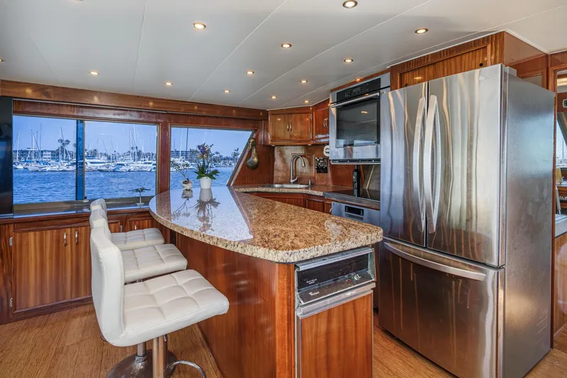 Maverick Yacht Photos Pics Luxurious kitchen interior of 1979 Hatteras 58 Motor Yacht with granite countertops and stainless appliances.