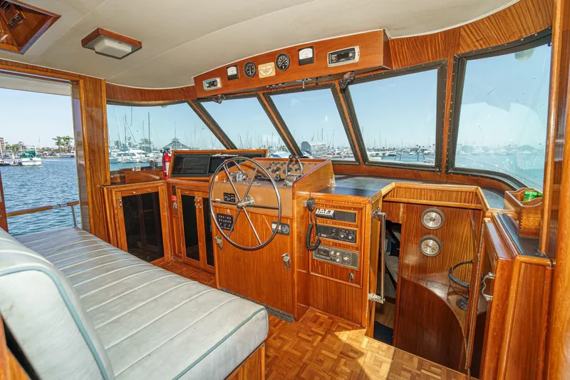 Maverick Yacht Photos Pics 1979 Hatteras 58 Motor Yacht helm with wood paneling and marina view.