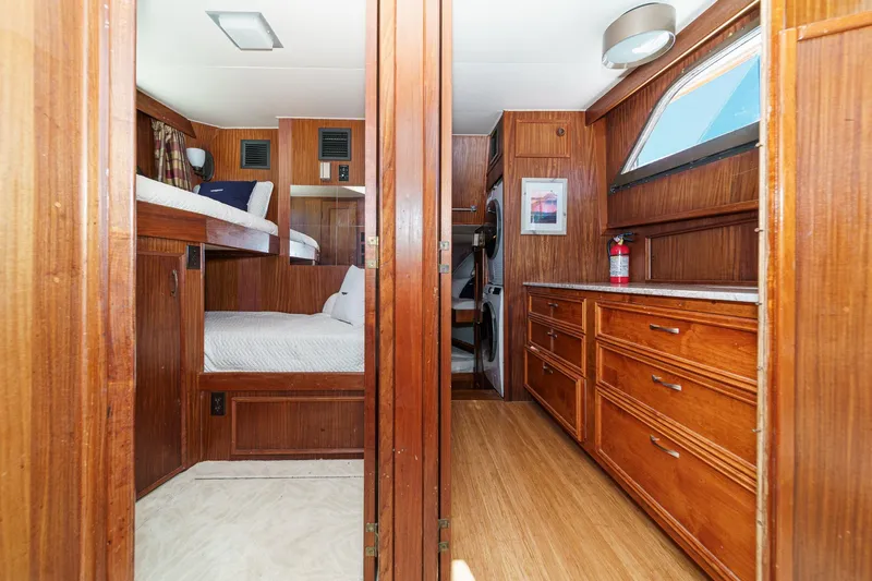 Maverick Yacht Photos Pics 1979 Hatteras 58 Motor Yacht interior with wooden cabinetry, bunk beds, and laundry area.