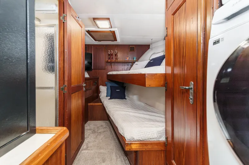 Maverick Yacht Photos Pics 1979 Hatteras 58 Motor Yacht interior with wooden cabinetry, bunk beds, and laundry area.