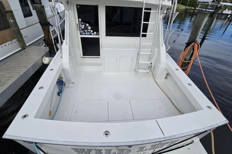 Wild Life Yacht Photos Pics 1989 Viking 45 Convertible boat docked, featuring spacious deck and ladder access.