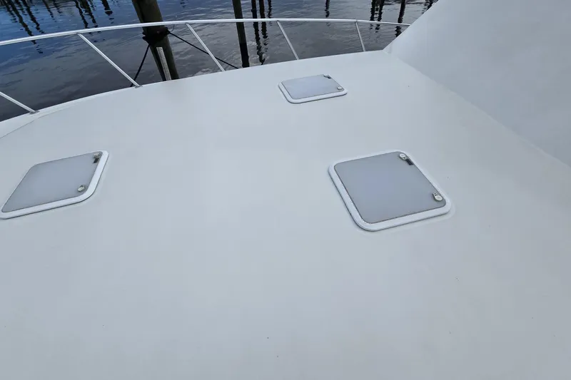 Wild Life Yacht Photos Pics 1989 Viking 45 Convertible yacht deck with hatches, docked by the water.