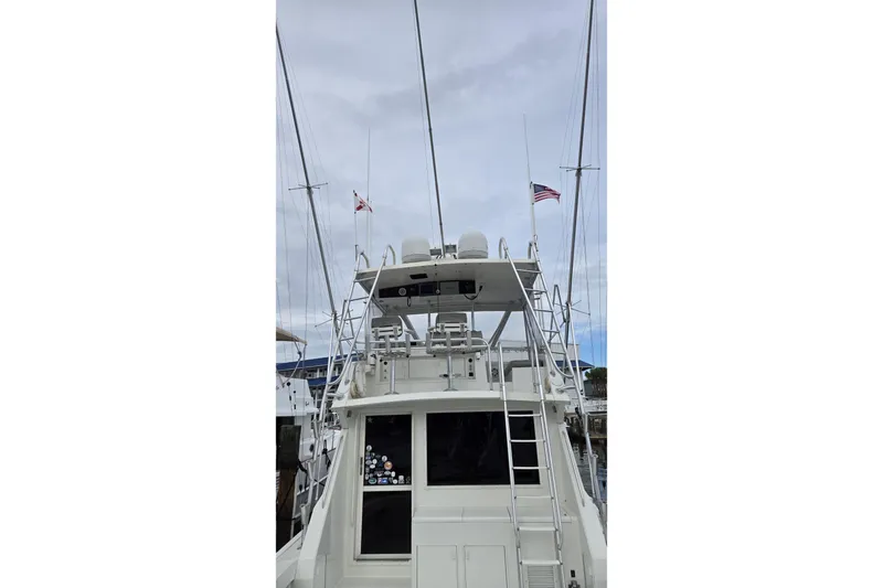 Wild Life Yacht Photos Pics 1989 Viking 45 Convertible yacht with flags, docked under cloudy skies.