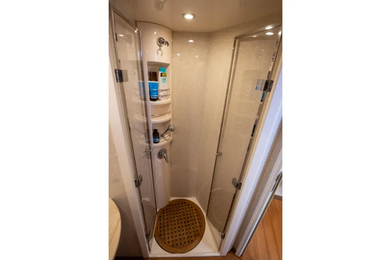  Yacht Photos Pics Shower area inside 2002 Pershing 52 yacht, featuring glass doors and built-in shelves.