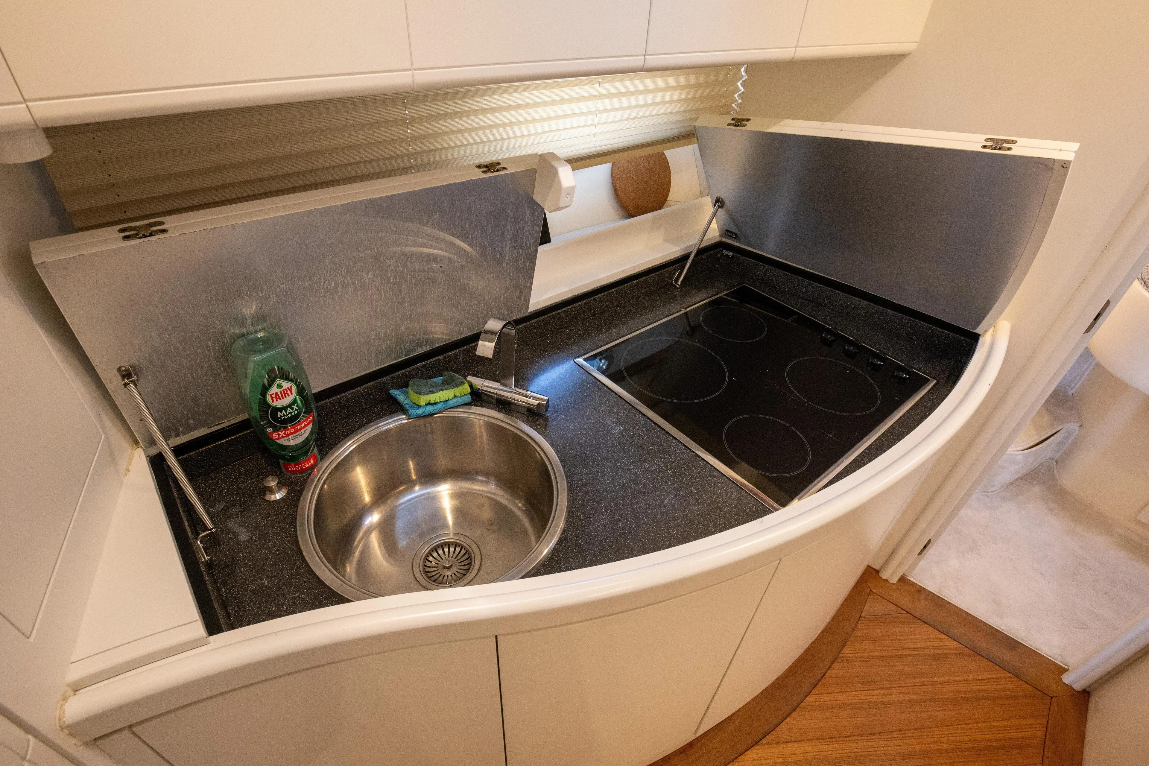  Yacht Photos Pics Compact kitchen area in a 2002 Pershing 52 yacht with sink and stovetop.